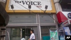 A woman walks by the office of The Voice Daily in Yangon, Myanmar, June 5, 2017. 