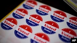 FILE - Stickers wait for voters at a polling place in Philadelphia, Nov. 5, 2013. 