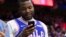 FILE - Rapper Meek Mill looks over his phone during the first half in Game 5 of a first-round NBA basketball playoff series between the Miami Heat and the Philadelphia 76ers, April 24, 2018, in Philadelphia. 