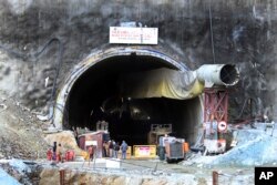 FILE - People stand near the entrance to the site of an under-construction road tunnel that collapsed in mountainous Uttarakhand state, India, Friday, Nov. 17, 2023. (AP Photo)