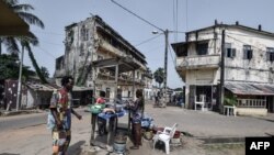 Une femme vend de la nourriture au bord d'une rue de Grand-Bassam, en Côte d'Ivoire, le 28 mars 2021.