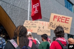 People hold up signs during a pro-Palestine rally and march on Temple University campus in Philadelphia, Pennsylvania, Aug. 29, 2024.