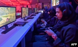 FILE - Saudi youths play at an electronic entertainment house accessible to men and women in Jeddah, Saudi Arabia, May 15, 2019.