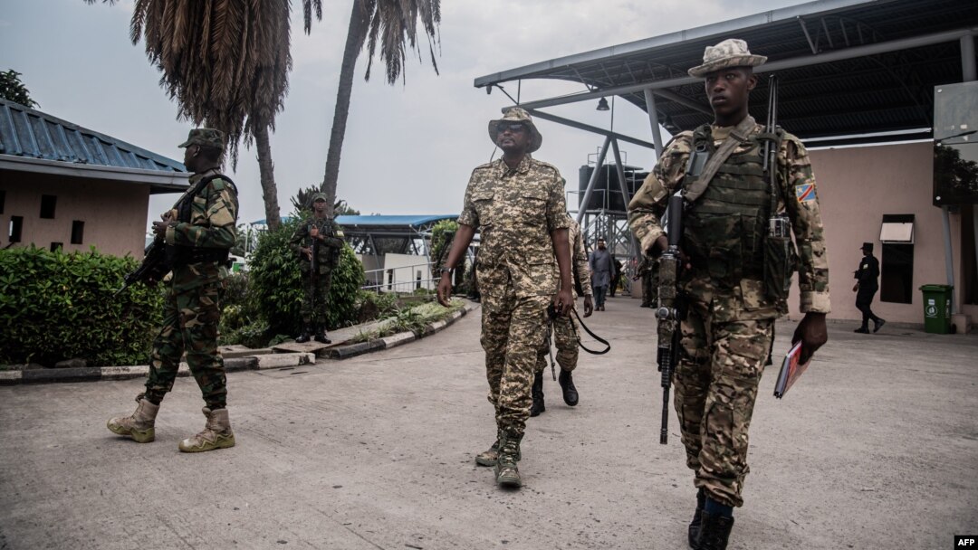 An M23 officer inspects the convoy repatriating Democratic Forces for the Liberation of Rwanda (FDLR) soldiers at the main border crossing between DR Congo and Rwanda in Goma on March 1, 2025.