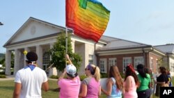 Manifestantes ondean una bandera gay frente al Centro Judicial del condado de Rowan, en Kentucky.