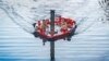 A group of people sit inside a hot tub boat sailing on the River Thames at Canary Wharf in London.