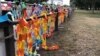 Paper links are draped over the fence at Hagley Park near one of the mosques were more than 40 people were killed in Christchurch, March 15, 2019. (S. Miller/VOA)