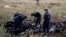 FILE - Members of the Ukrainian Emergencies Ministry work at a crash site of Malaysia Airlines Flight MH17, near the village of Hrabove, Donetsk region, July 20, 2014.