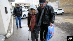 Azerbaijani rights activist Leyla Yunus walks with her husband Arif Yunus after she was released from prison in Baku, Azerbaijan, Dec. 9, 2015.