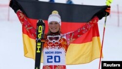 Germany's winner Maria Hoefl-Riesch poses with a German flag during the flower ceremony after competing in the slalom run of the women's alpine skiing super combined event during the 2014 Sochi Winter Olympics on Feb. 10, 2014. 