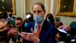 Sen. Ron Wyden, D-Ore., speaks to reporters following a Democratic strategy meeting at the Capitol in Washington.