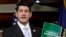 FILE- Congressman Paul Ryan holds a copy of the 2014 Budget Resolution, March 2013.