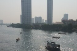 Boats float along the river in Bangkok, which is facing rising sea levels and sinking land. (VOA News)