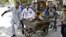 Afghans rush wounded man to treatment after a suicide car bomber strikes outside Supreme Court, Kabul, June 11, 2013.