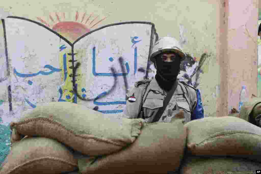 A soldier stands guard outside a polling station during the first day of the presidential election in Cairo, May 26, 2014.