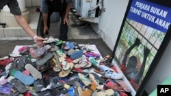 Officials from Indonesia's Child Protection Commission collect sandals sent to their office in Jakarta by outraged citizens as part of a campaign to support a boy who was beaten by police and faces five years in jail for stealing footwear, January 4, 2012