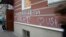 FILE - A man walks by the office of "Memorial" rights group in Moscow, Russia, Nov. 21, 2012. The building's facade is seen defaced with graffiti reading “Foreign Agent (Loves) USA.”