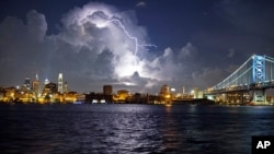 Lightning illuminates storm clouds over the Philadelphia skyline, Tuesday, August 16, seen from across the Delaware River in Camden, New Jersey.