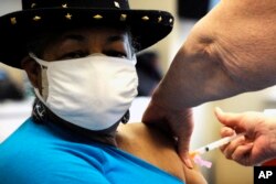 Georgette Moon receives a COVID-19 vaccine at the county health department in Tuskegee, Ala., Monday, Jan. 25, 2021. (AP Photo/Jay Reeves)