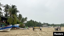 Residents carry wooden tables ahead of the arrival of Storm John, in Puerto Escondido, Oaxaca state, Mexico, Sept. 23, 2024.