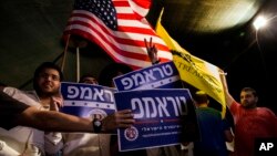 Mideast Israel Trump: Israelis wave flags and hold signs during a rally, sponsored by Republicans Overseas Israel, a local organization that encourages American expatriates to cast absentee ballots for Republican presidential candidate Donald Trump, in Je