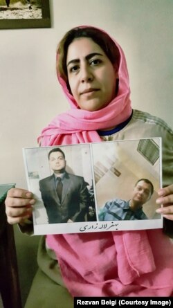 Tehran resident Rezvan Beigi holds photos of her jailed husband Behfar Lalezari, whose life she said is in danger because he has been denied medical treatment in a hospital for serious health problems.