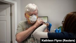 Fred Laredo, 72, sedang disuntik vaksin COVID-19 oleh Dr. Lishunda Franklin di New Orleans, Louisiana, AS, 8 Januari 2021. (Foto: REUTERS/Kathleen Flynn)