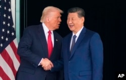 资料照片：在韩国釜山金海国际机场，美国总统唐纳德·特朗普与中国国家主席习近平在举行美中峰会会谈后握手。(2025年10月30日)