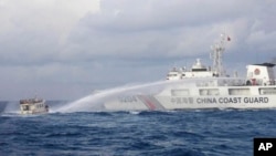 (FILE) A Chinese Coast Guard ship uses water cannons on Philippine navy-operated supply boat in the South China Sea.