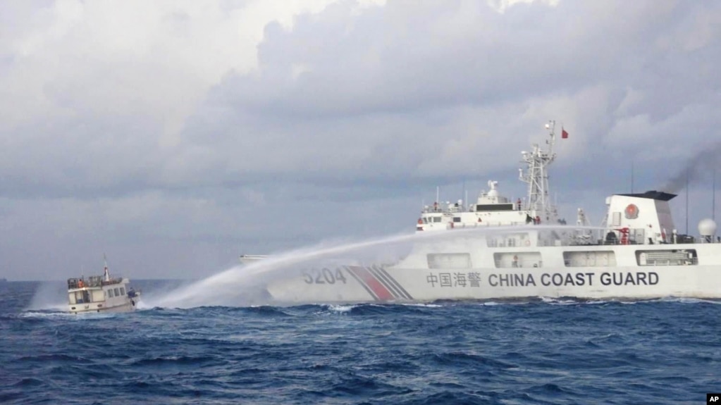 资料照片：菲律宾海警队2023年12月10日的照片显示中国海警船向菲律宾供给船发射水炮。(photo:VOA)