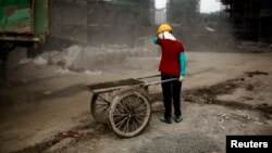 FILE - A female migrant construction worker is seen at a building site in Shanghai, China, July 2, 2013.