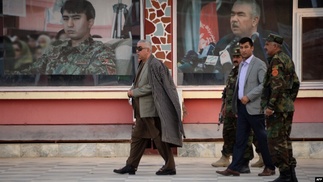 Afghan First Vice President Abdul Rashid Dostum, left, walks at his headquarters in Sheberghan, capital of northern Jowzjan province, July 28, 2015.