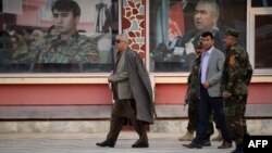 Afghan First Vice President Abdul Rashid Dostum, left, walks at his headquarters in Sheberghan, capital of northern Jowzjan province, July 28, 2015.