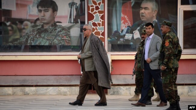 Afghan First Vice President Abdul Rashid Dostum, left, walks at his headquarters in Sheberghan, capital of northern Jowzjan province, July 28, 2015.