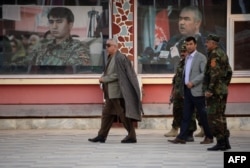 FILE - Abdul Rashid Dostum (L) walks in Sheberghan, capital of northern Jowzjan province, Afghanistan, July 28, 2015..