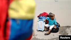 A Venezuelan boy sits next to family belongings at the Pacaraima border control, Roraima state, Brazil, Aug. 20, 2018. 