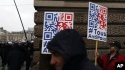 FILE - Demonstrators march in opposition to the introduction of a vaccine pass to curb the spread of COVID-19, in Paris, France, Jan. 8, 2022.