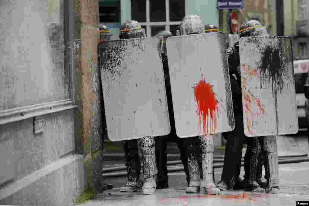 Paint covers the shields of French CRS riot police during clashes with protesters in Nantes, western France, to demonstrate against the construction of a new airport in Notre-Dame-des-Landes, some 30 kilometres (19 miles) away.