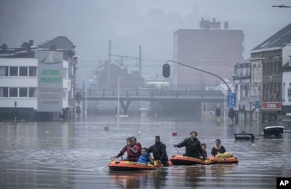 Des personnes utilisent des radeaux en caoutchouc dans les eaux de crue après que la Meuse soit sortie de son lit lors de fortes inondations à Liège, en Belgique, jeudi 15 juillet 2021.