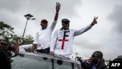 Félix Tshisekedi ,à droite, leader de l'Union pour la démocratie et le progrès social (UDPS) et son allié de l'Union pour la nation congolaise (UNC), Vital Kamerhe, à gauche, saluent leurs partisans après leur retour à Kinshasa, le 27 novembre 2018.