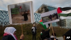 Demonstrators carry banners and Palestinian flags outside the International Criminal Court, ICC, urging the court to prosecute Israel's army for war crimes in The Hague, Netherlands, Nov. 29, 2019. 
