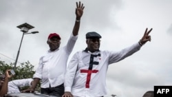 Félix Tshisekedi (à droite), leader de l'Union pour la démocratie et le progrès social (UDPS) et son allié de l'Union pour la nation congolaise (UNC), Vital Kamerhe (à gauche), saluent leurs partisans après leur retour à Kinshasa, le 27 novembre 2018.