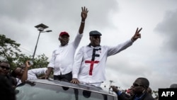 Félix Tshisekedi (à droite), leader de l'Union pour la démocratie et le progrès social (UDPS) et son allié de l'Union pour la nation congolaise (UNC), Vital Kamerhe (à gauche), saluent leurs partisans après leur retour à Kinshasa, le 27 novembre 2018.