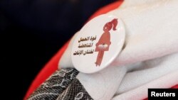 A badge reads "The power of labor against FGM" is seen on a volunteer during a conference on International Day of Zero Tolerance for Female Genital Mutilation (FGM) in Cairo, Egypt, Feb. 6, 2018. 