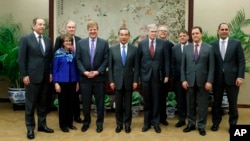 Myron Brilliant, fourth left, executive vice president and head of International Affairs at the U.S. Chamber of Commerce, Chinese State Councilor and Foreign Minister Wang Yi, fifth left, and other delegates take a group photo ahead of a meeting at the Ministry of Foreign Affairs