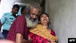 Asha Moni, right the wife of murdered Bangladeshi blogger Niloy Chakrabarti who wrote under the name Niloy Neel, weeps outside her home in Dhaka on August 8, 2015. 