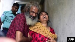 Asha Moni, right, the wife of murdered Bangladeshi blogger Niloy Chakrabarti, weeps outside her home in Dhaka on August 8, 2015. 