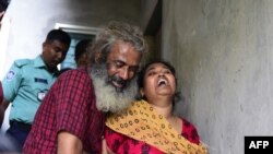 Asha Moni, right the wife of murdered Bangladeshi blogger Niloy Chakrabarti who wrote under the name Niloy Neel, weeps outside her home in Dhaka on August 8, 2015. 