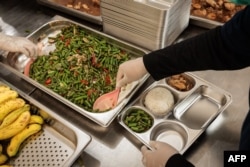 Staf menyiapkan makanan untuk dikirim ke sekolah di dapur pada hari pertama program makanan gratis di Jakarta pada 6 Januari 2025. (Yasuyoshi CHIBA / AFP)