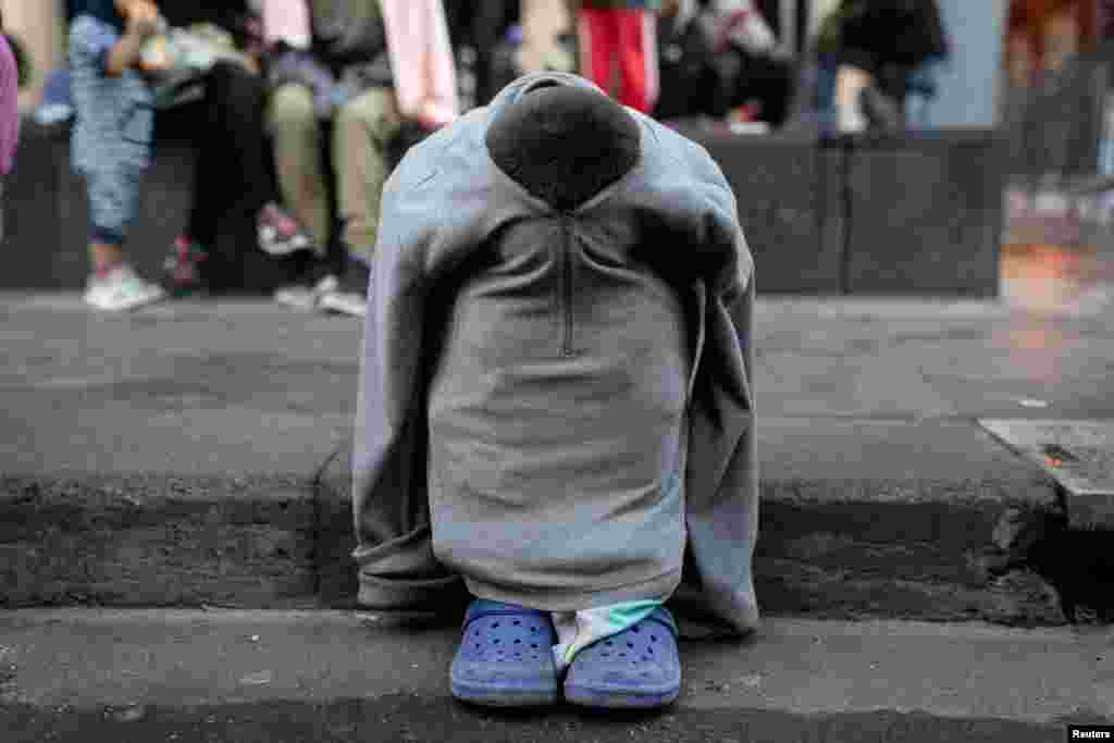 A child takes cover during a protest in favor of migration in Mexico City, Mexico.